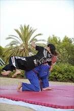 Woman and a man doing martial arts training in a park