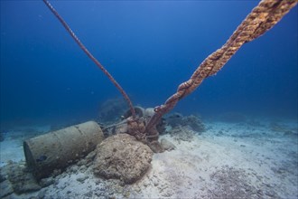 An anchor made of concrete blocks and old barrels at a coral reef