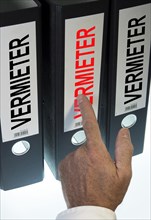 Hand pointing to a file folder labeled 'Vermieter'
