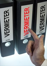 Hand pointing to a file folder labeled "Vermieter"