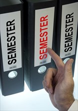 Hand pointing to a file folder labeled 'Semester'