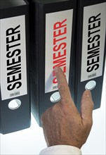 Hand pointing to a file folder labeled 'Semester'