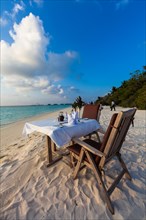 A table laid for dinner standing on the beach