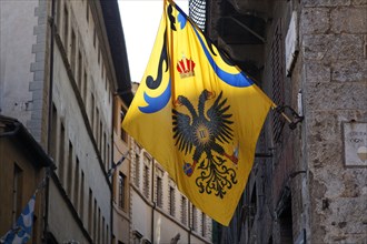 Flag of a contrada district in an alley of the historic town centre