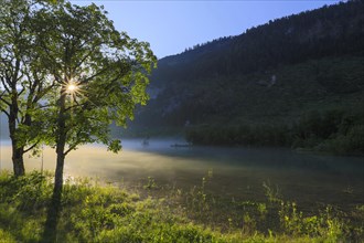 Lake near Gosau in the morning mist with sunrays