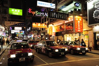 Red taxis on a street in Tsim Sha Tsui at night