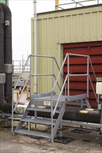 Steps giving access over roof top industrial plant pipework