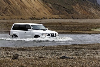 4WD car driving through water
