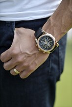 A man's hand with a Breitling watch and a wedding ring