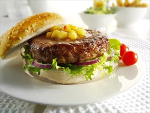 Beef burger with sweetcorn relish and salad in a bun