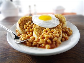 Baked beans on crumpets with fried egg on top