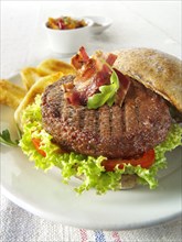 Beef burger in a wholemeal bun with salad and French fries