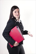 Businesswoman holding a red folder in her arm with a questioning attitude