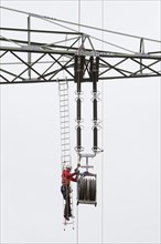 Lineman working with a wire rope hoist on a 380-kV long-distance line owned by the 50Hertz transmission system operator