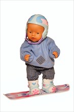 Baby doll with ski clothes on a snowboard