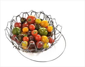 Various wild tomatoes in a wire basket