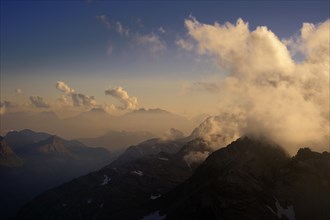 Mountain panorama in the evening light with clouds in the sky