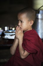 Buddhist novice praying in a monastery