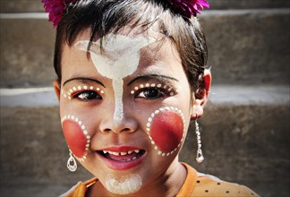 Smiling girl with thanaka paste on her face in Mandalay