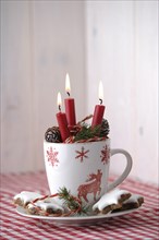 Christmas ambience with a tea cup and burning candles