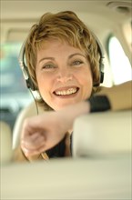 Business woman with headphones sitting in a car