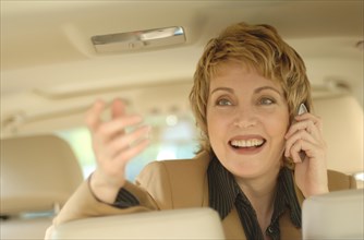 Businesswoman making a phone call in a car