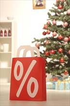 Shopping bag with a percent sign in a festive Christmas environment