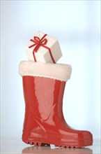 Red rubber Santa Claus boot with a gift