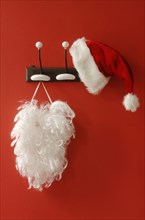 Santa hat and beard hanging on nostalgic coat hooks