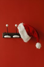 Santa Claus hat hanging on nostalgic coat hooks