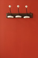 Nostalgic coat hooks on red wall