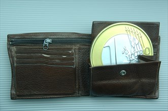 Oversized euro coin in a wallet