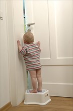 Toddler standing on a stool