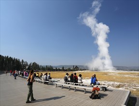Tourists watching the eruption of the Old Faithful geyser