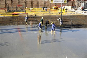 Construction workers laying a concrete floor