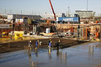 Construction workers laying a concrete floor or ceiling