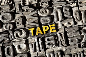 Old lead letters forming the word 'TAPE'