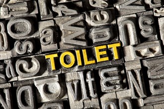 Old lead letters forming the word "TOILET"