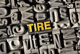 Old lead letters forming the word Tire