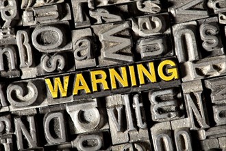 Old lead letters forming the word Warning