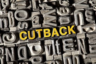 Old lead letters forming the word Cutback