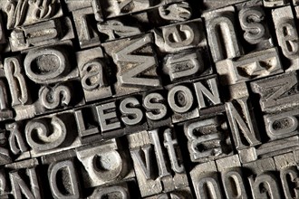 Old lead letters forming the word 'LESSON'