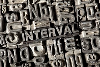 Old lead letters forming the word 'INTERVAL'
