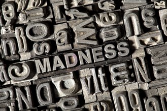 Old lead letters forming the word "MADNESS"