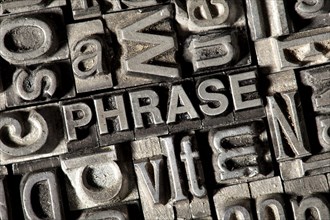 Old lead letters forming the word "PHRASE"