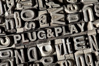 Old lead letters forming the term 'Plug & play'
