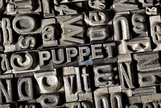 Old lead letters forming the word 'PUPPET'