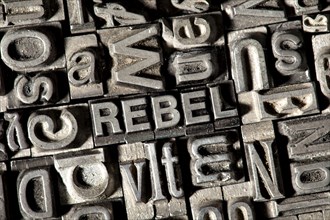 Old lead letters forming the word 'REBEL'
