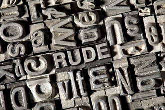 Old lead letters forming the word RUDE