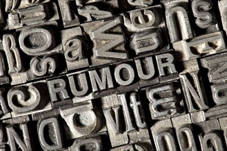 Old lead letters forming the word RUMOUR